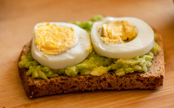 istock avocado toast topped with a perfectly boiled egg, presented on a rustic wooden board 1716555456