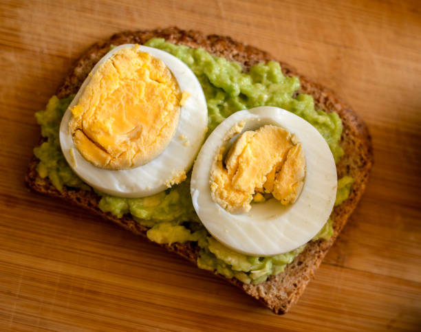 istock avocado toast topped with a perfectly boiled egg, presented on a rustic wooden board 1716555460