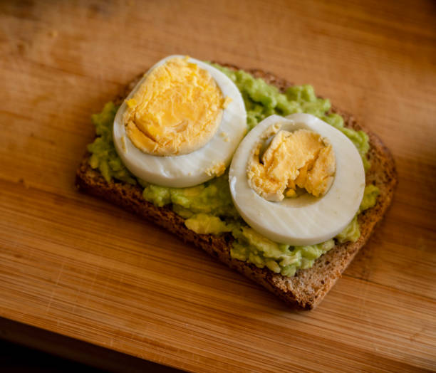 istock avocado toast topped with a perfectly boiled egg, presented on a rustic wooden board 1716555463