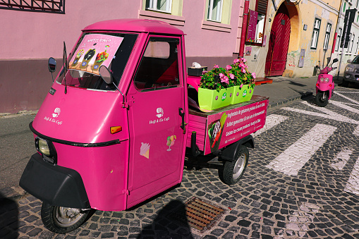 Heiss and Eis Cafe, smallest coffee shop in Sibiu. Front window for ordering and an auto rickshaw (Tuk tuk) all in bright pink