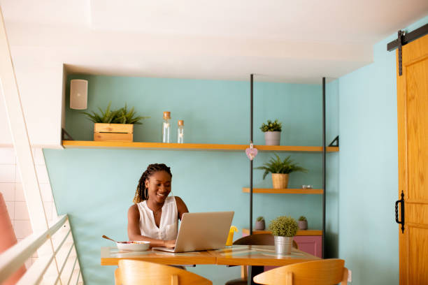 istock Young black woman drinking coffee  while working on laptop in the cafe 1716573282