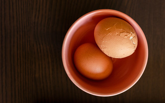 Boiled Eggs in a Pink Bowl on Wooden Board