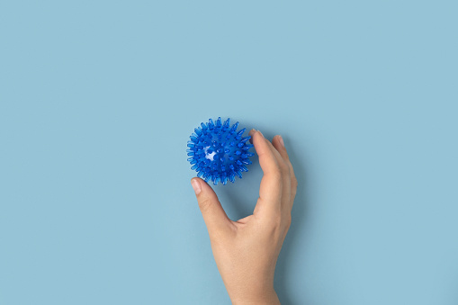Massage ball. Tactile knobby ball on blue studio background. Sensory massage textured ball. Enhance the cognitive, physical process. Brain development. Support for Children with ADHD, autism, fidgeting. Squeezy toy. Colorful sensory balls. Tactile massage toys. People development, health. Patient pressing, crushing Textured rubber ball set, colorful soft squeezy sensory prickly toys. Stress reliever. Stimulate. Hand grip balls. Massage soft ball, roller.  occupational therapy, peeling or massage with hedgehog ball. spiky trigger point ball, muscle pain treatment reflexology, deep tissue massage. self massage