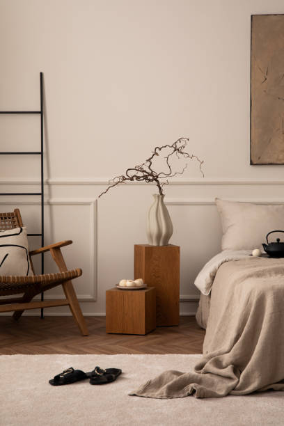 istock Creative composition of bedroom interior with mock up poster frame, cozy bed, beige bedding, wooden bedside table, rattan armchair, patterned pillow and personal accessories. Home decor. Template. 1716610026