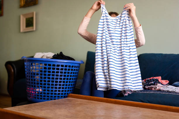 istock Little girl folding her clothes at home 1716618414