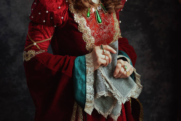 Closeup on medieval queen in red dress with handkerchief stock photo