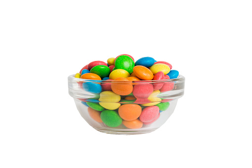 Multicolor small mixed colored chocolate coated candies in bowl, isolated on white.