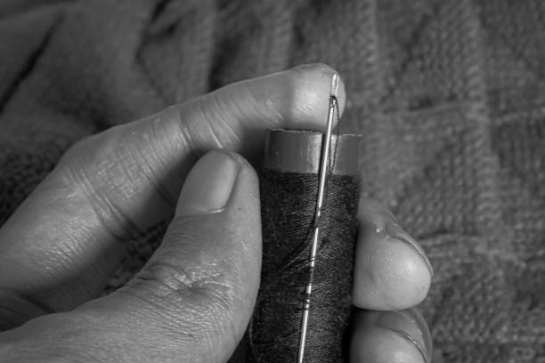 istock figure of hands holding sewing needle and thread. 1716637686