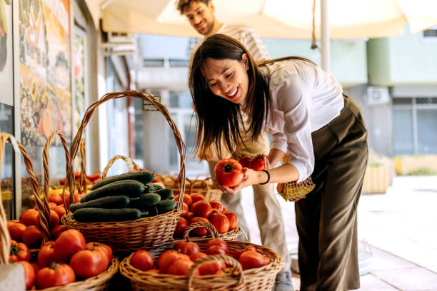 Young couple buying vegetables at small store