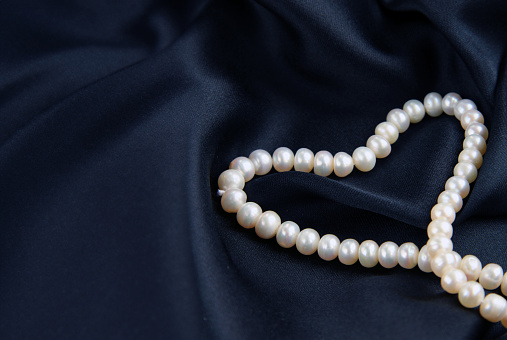 pearls on a silk background, heart shape