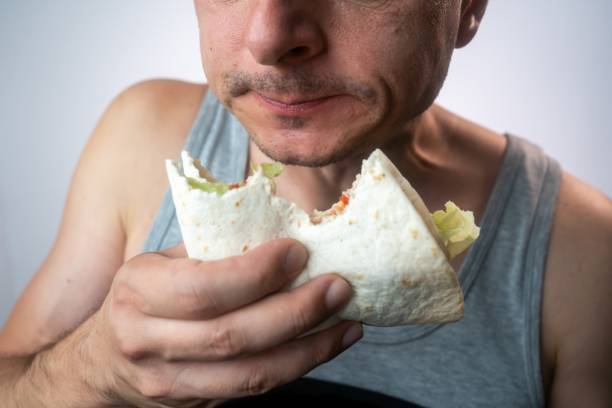 istock Enjoying Eating a Taco, close up 1716656585