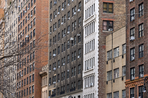New York City - February 19: air conditioners on house facade in Manhattan on February 19, 2023 in New York City, NY. Manhattan is the most densely populated borough of New York City.