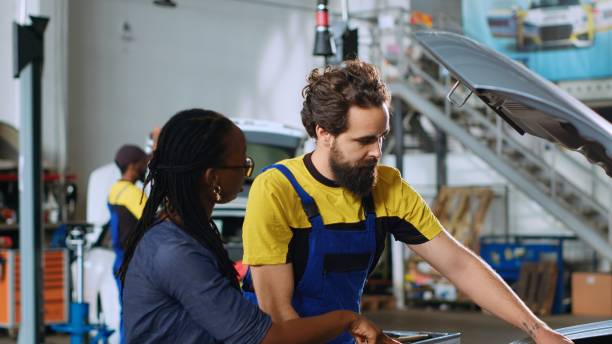 istock Serviceman showing client car damages 1716699937