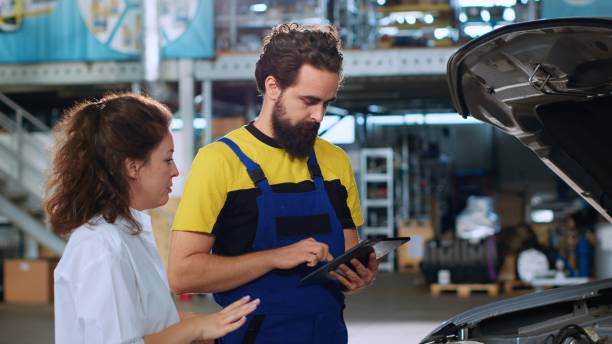 istock Mechanic calculates car fixing services 1716703153