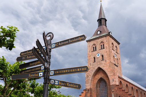 A post with indications of the directions of tourist attractions in the town of Odense, Denmark.