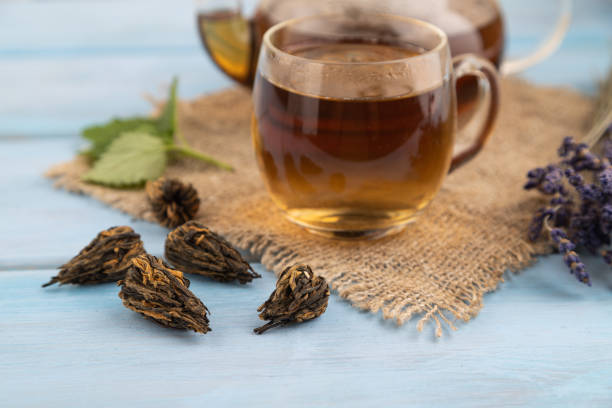 istock Red tea with herbs in glass on blue wooden. Side view, selective focus. 1716720701