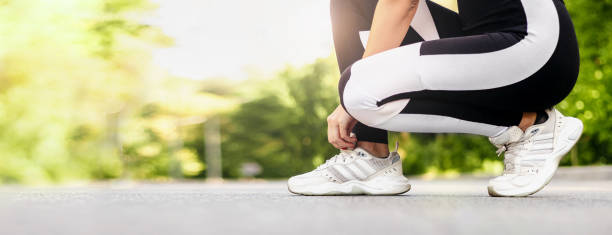 istock woman getting ready for jogging outdoors while lacing her sneakers 1716722340