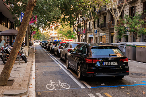 Barcelona, Spain - September 16, 2023: Cycle lane and parked cars on the street in Barcelona, Spain.