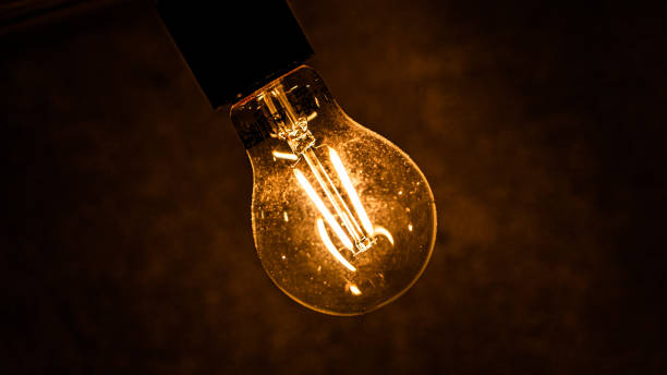 istock Glowing light bulb on dark background closeup. Finding innovative solution of complicated task concept. Bright lamp illuminates space as creative idea for development and progress 1716731375