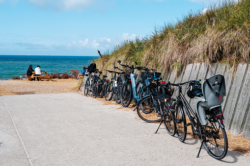 Copenhagen, Denmark - August 8, 2023: Electric bicycles park near a beach.
