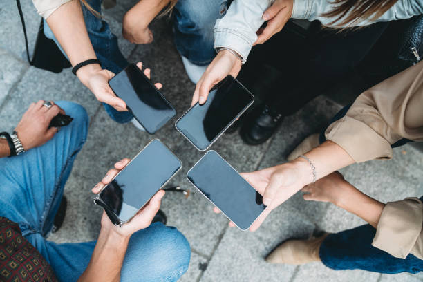 istock Four friends are sharing informations with smart phones 1716761119