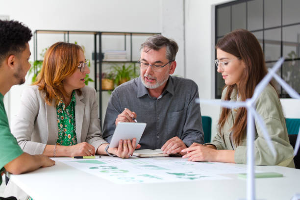 istock Business colleagues discussing over digital tablet while sitting at desk in office during meeting 1716763894