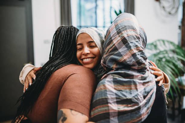 Close up shot of three friends embracing each other Close up shot of three friends embracing each other. They are smiling, supporting each other. moroccan girl stock pictures, royalty-free photos & images