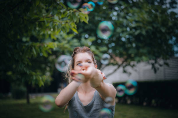 istock Young woman playing with soap bubbles 1716769574