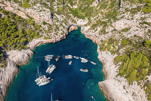 Tourist boats at famous Stiniva cove, Vis island, Dalmatia, Croatia. High angle view from drone.