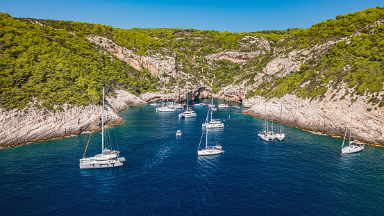 Tourist boats at famous Stiniva cove, Vis island, Dalmatia, Croatia. High angle view from drone.