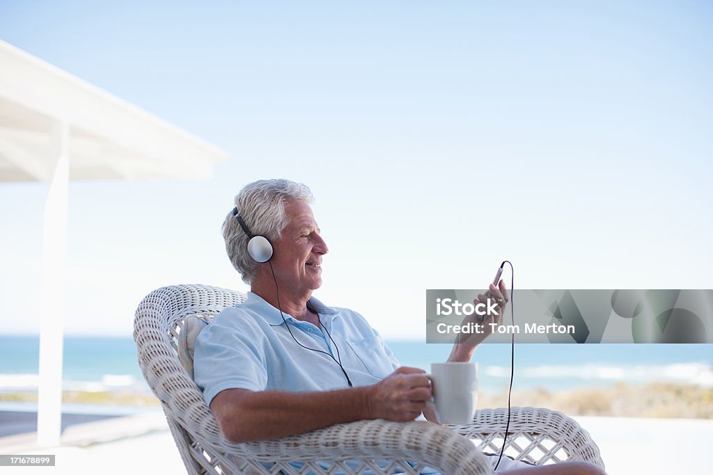 Senior man listening to mp3 player  60-64 Years Stock Photo