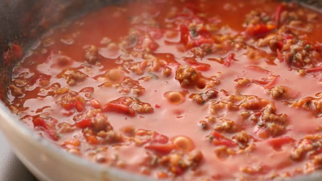 Minced meat and tomato sauce are boiled in a frying pan