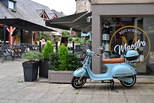 Dinan, Brittany, France, September 8, 2023 - The scooter Oxygo Super Tango, an electric replica of the VESPA ACMA 1957 in the medieval old town of Dinan.