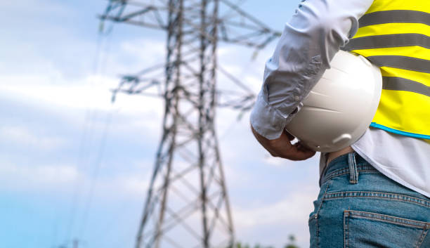 istock A male power engineer in a white helmet checks a power line using data from electrical sensors on a tablet. High voltage electrical lines at sunset. Distribution and supply of electricity. clean energy 1716813764
