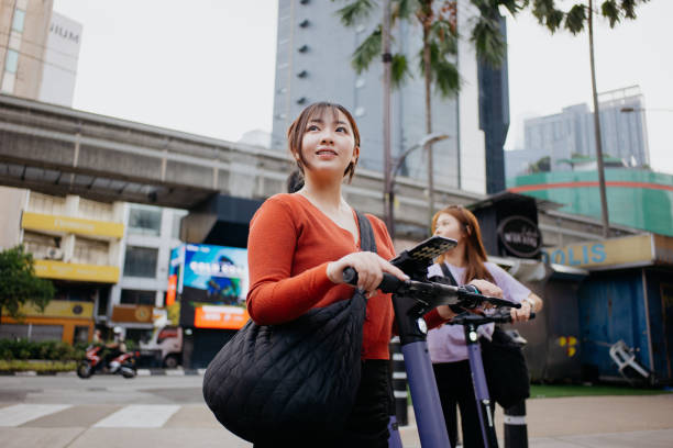 istock Young asian woman navigating with smartphone while riding an e-scooter 1716813837