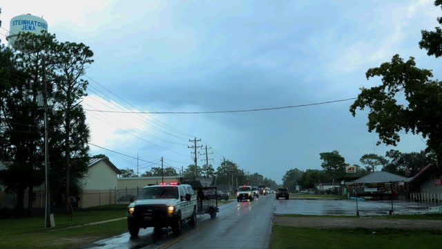 Ambulance and rescue convoy pass on post storm road. Hurricane zone in small towns of North Florida. Driving plate
