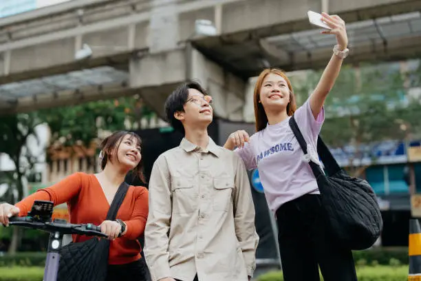 Young asian people taking selfie with smartphone in the city