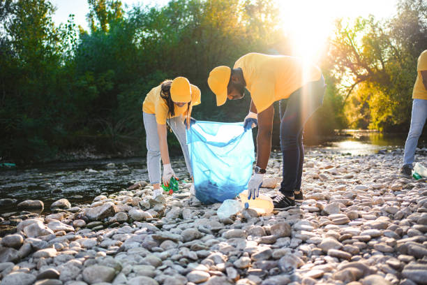 istock Two multiracial volunteers cleaning riverbank from trash 1716817247