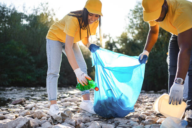 istock Two multiracial volunteers cleaning riverbank from trash 1716817251