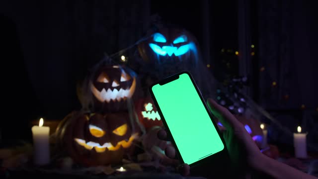 Pyramid of 6 holiday lanterns made of carved pumpkins glow with colorful lights in the smoke in the dark