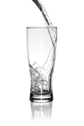 Photo in the studio, water is poured into a glass.