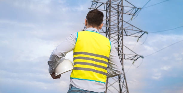 istock A male power engineer in a white helmet checks a power line using data from electrical sensors on a tablet. High voltage electrical lines at sunset. Distribution and supply of electricity. clean energy 1716836659