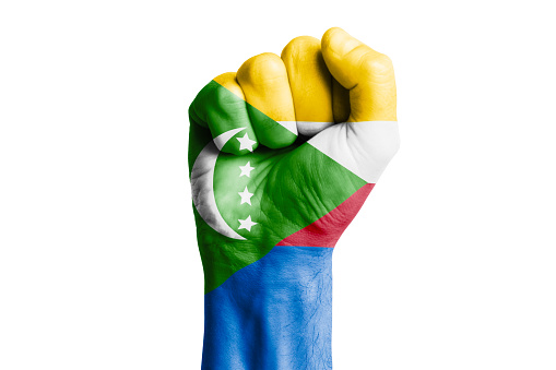 Man hand fist of COMOROS flag painted. Close-up