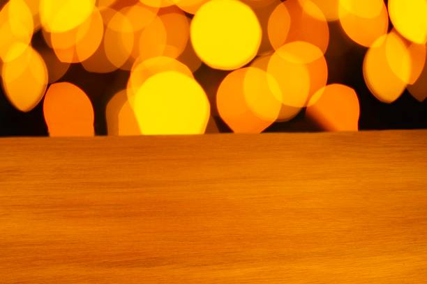 Empty wooden table at home with blurred yellow light in the background