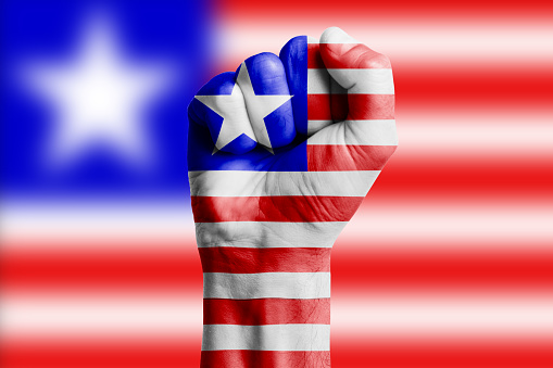 Man hand fist of LIBERIA flag painted. Close-up