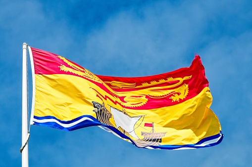 Flag of the Channel Island of Jersey fluttering against a blue sky