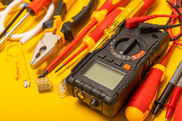 istock Electrician tools on background.Multimeter,construction tape,electrical tape, screwdrivers,pliers,an automatic insulation stripper, socket and LED lamp.Flatley.electrician concept. 1716859947