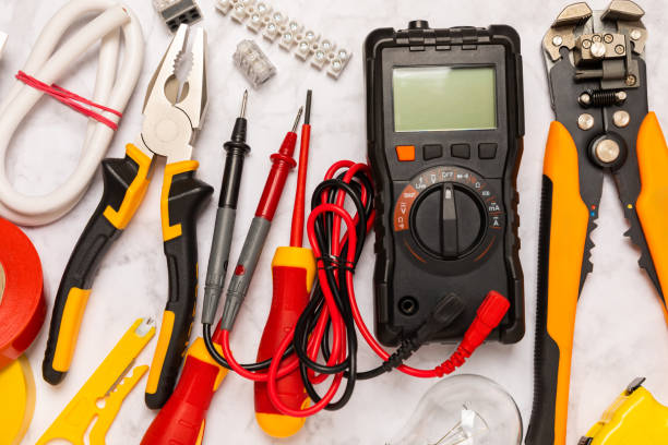 istock Electrician tools on background.Multimeter,construction tape,electrical tape, screwdrivers,pliers,an automatic insulation stripper, socket and LED lamp.Flatley.electrician concept. 1716859953