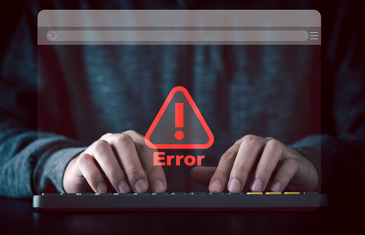 Businessman typing on computer keyboard with virtual monitor red triangle caution warning sign for notification error and maintenance concept.