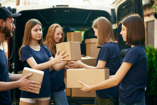 istock Young people, volunteers in uniform loading boxes into van. Gathering food, clothes, meds for people and animals in need 1716898082